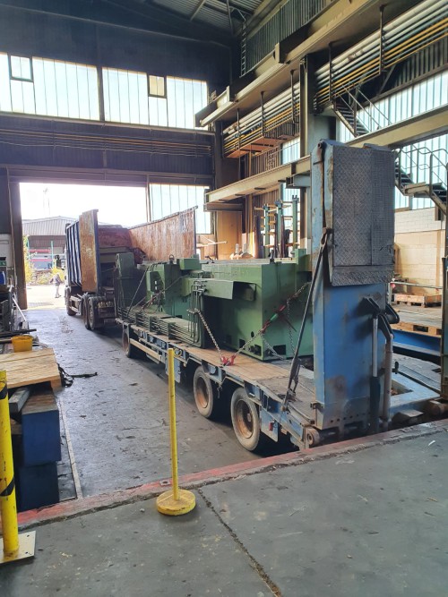 Professioneller Maschinentransport mit gesicherter Ladung auf der Straße