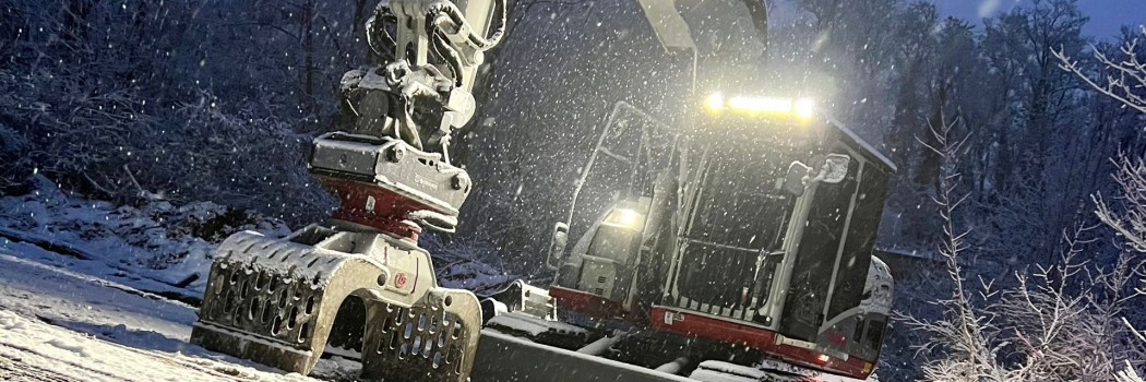 Bagger bei Nacht im Wintereinsatz mit Beleuchtung - zuverlässiger Service rund um die Uhr