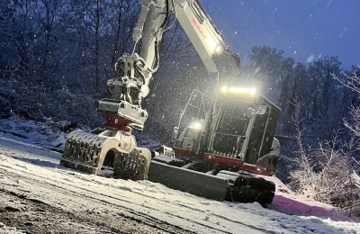 Bagger bei Nacht im Wintereinsatz mit Beleuchtung - zuverlässiger Service rund um die Uhr