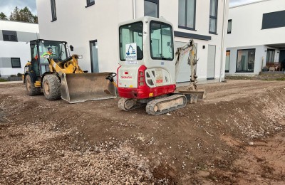 Bagger und Radlader im Einsatz auf Baustelle - professionelle Baumaschinen zur Miete